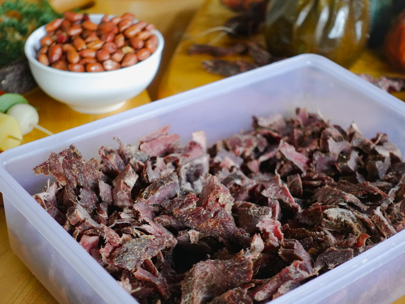 Sliced South African biltong with rosemary on a wooden board