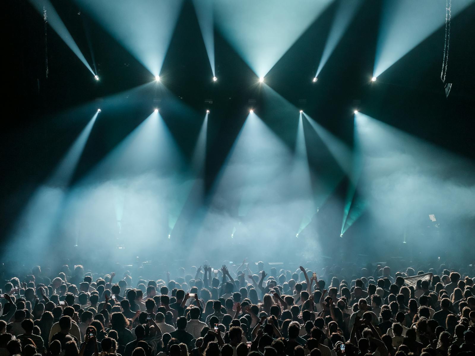 Massive festival crowd enjoying live music under stage lights