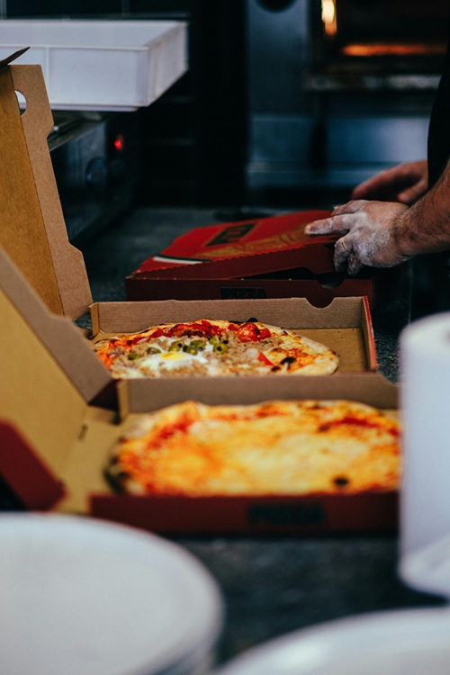Hot, fresh pizzas being prepared, ready for delivery